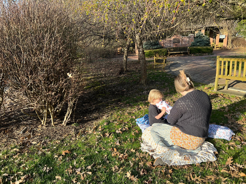 A family uses a Stout House adventure mat in a park